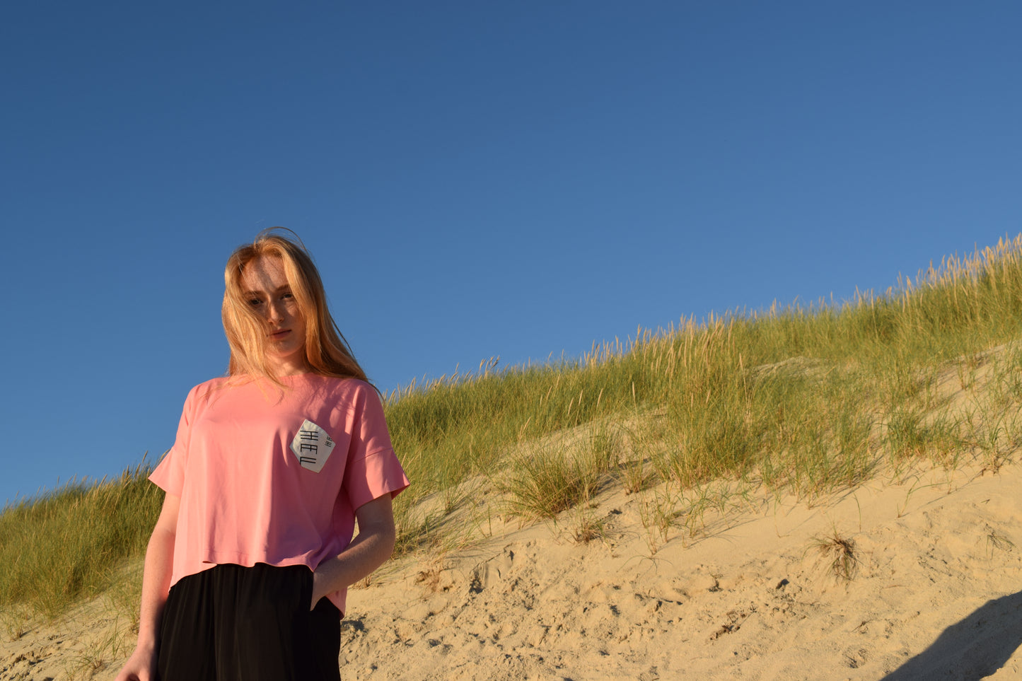 HEL T-Shirt Boxy fit in Pink mit Brusttasche am Strand von Sylt
