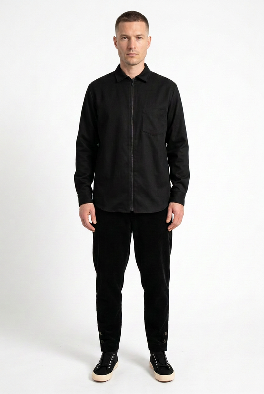Männermodel mit natürlicheren Wangenknochen und kurzem Haar im schwarzen Overshirt-Look
